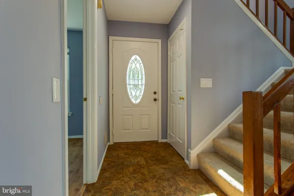 a view of a hallway with wooden floor and entryway