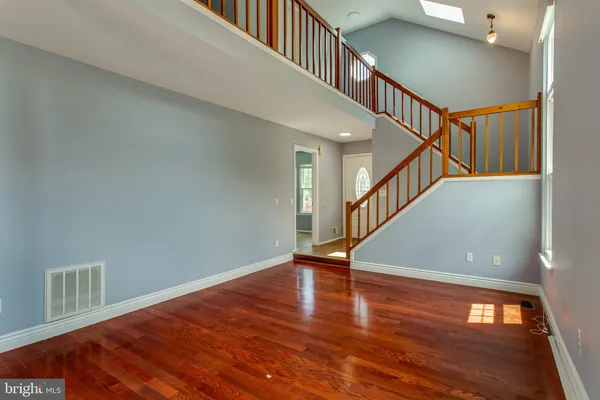 a view of a hallway with wooden floor and stairs