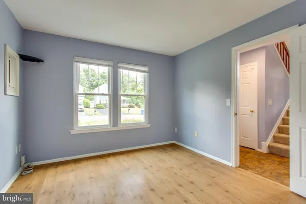 an empty room with a fireplace and wooden floor