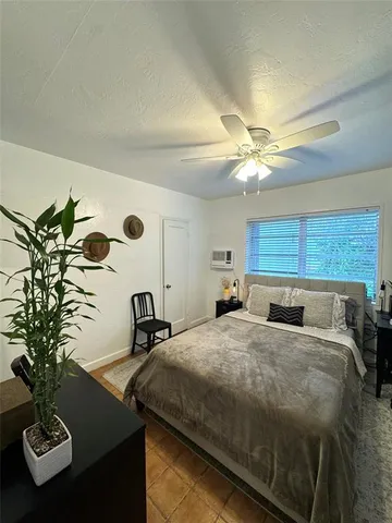 a bedroom with a bed and a potted plant