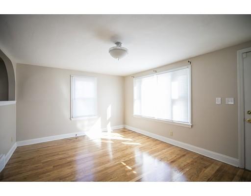 302 Island Pond Road Springfield, MA 01118 - Photo 3 of 25 a view of an empty room with wooden floor and a window