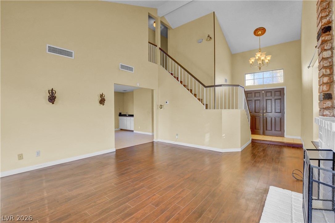 6440 Hartwood Road Las Vegas, NV 89108 - Photo 8 of 59 A grand entryway features a graceful staircase and rich wood flooring, establishing an inviting ambiance.