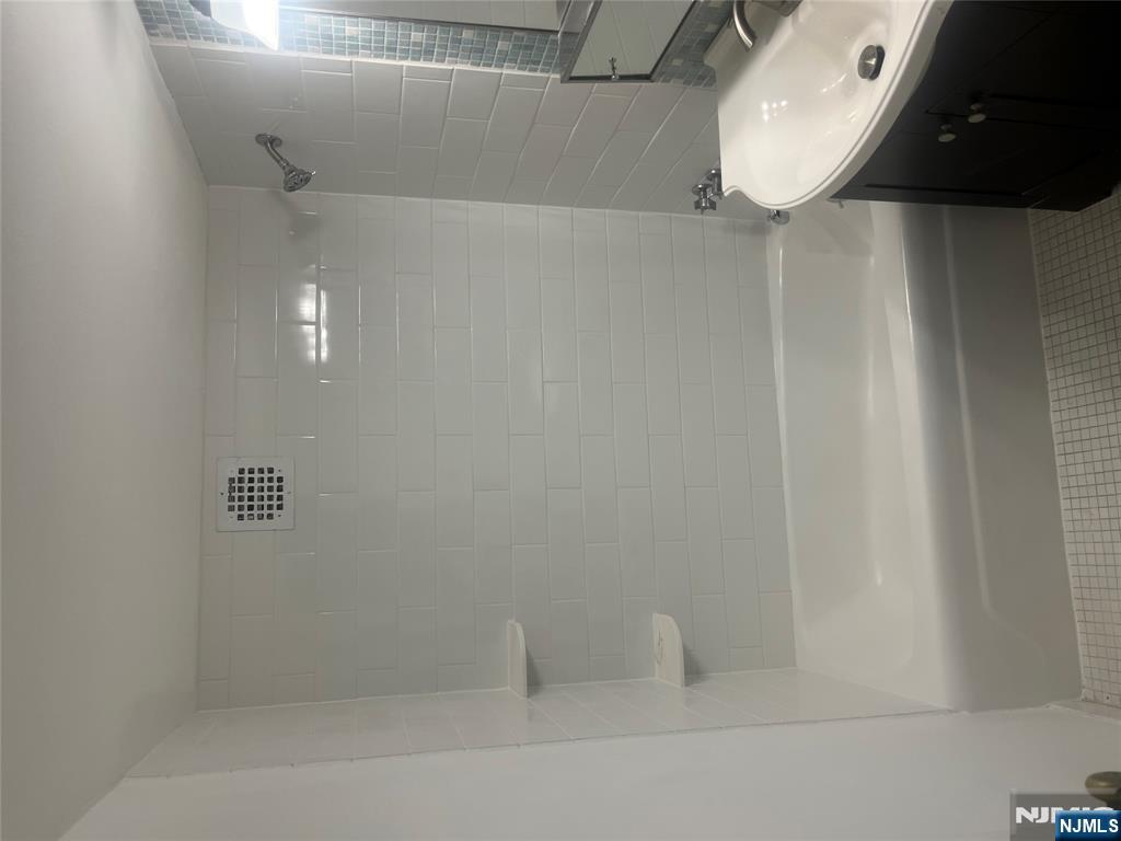 265 Main Street, Unit 506 Ridgefield Park, NJ 07660 - Photo 4 of 8 a bathroom with a bathtub and a shower