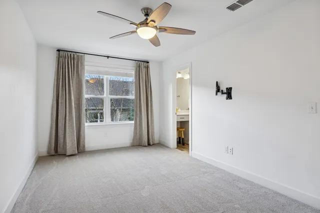 an empty room with closet and a ceiling fan