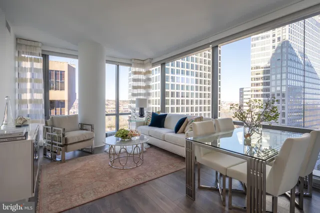 a living room with furniture and floor to ceiling windows
