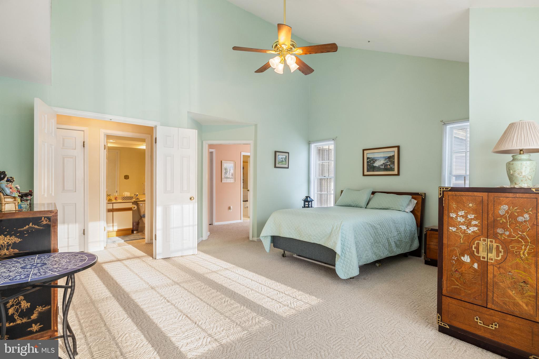 2702 Summerview Way, Unit 303 Annapolis, MD 21401 - Photo 12 of 35 a spacious bedroom with a bed a dresser and a chandelier