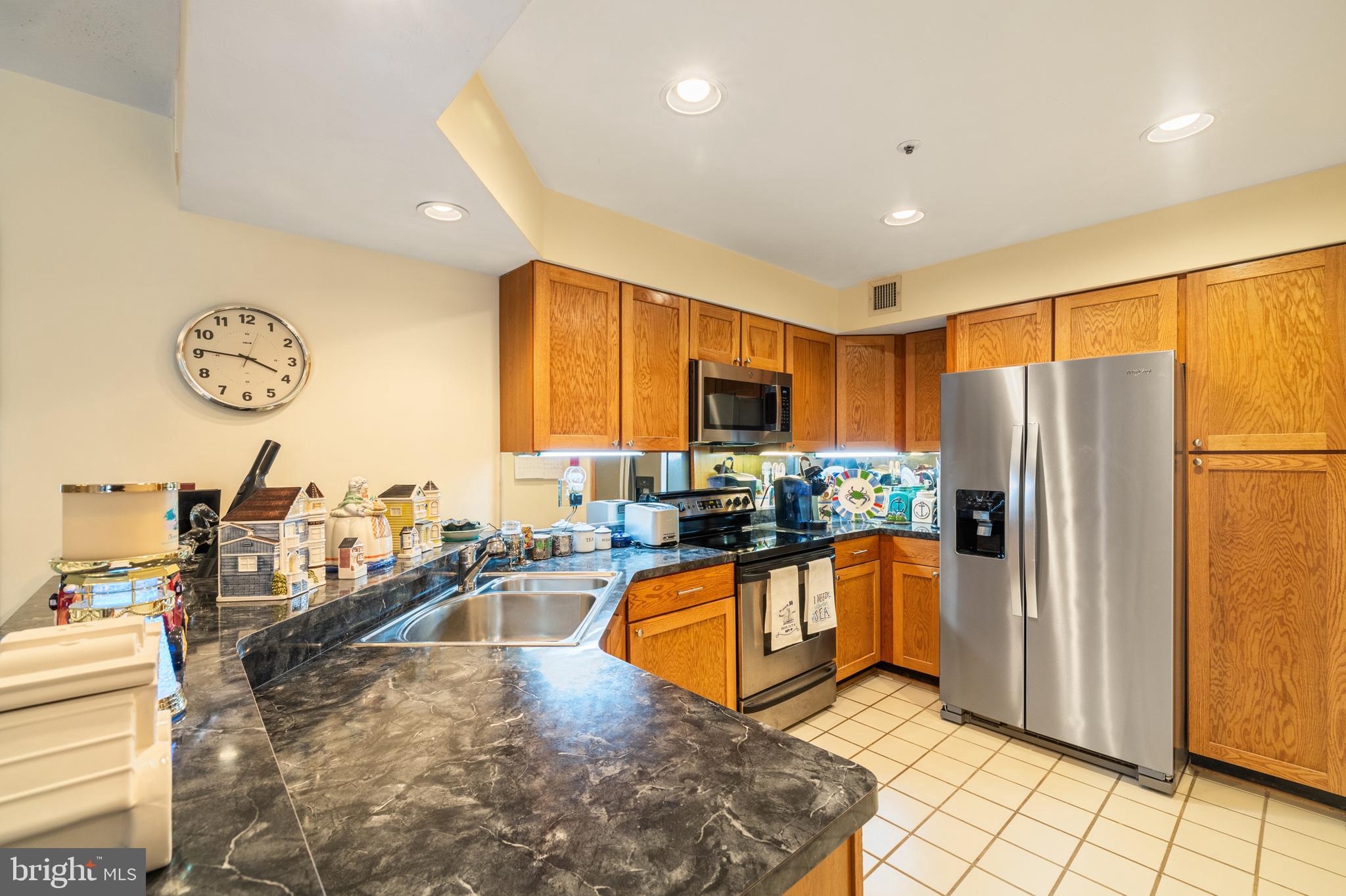 2702 Summerview Way, Unit 303 Annapolis, MD 21401 - Photo 8 of 35 a kitchen with stainless steel appliances granite countertop a refrigerator a sink a stove top oven and a dining table