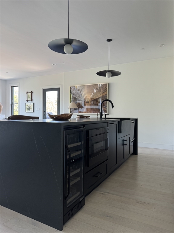 347 Maverick Street, Unit 5 Boston, MA 02128 - Photo 9 of 15 a kitchen with kitchen island granite countertop a sink a counter space and a window