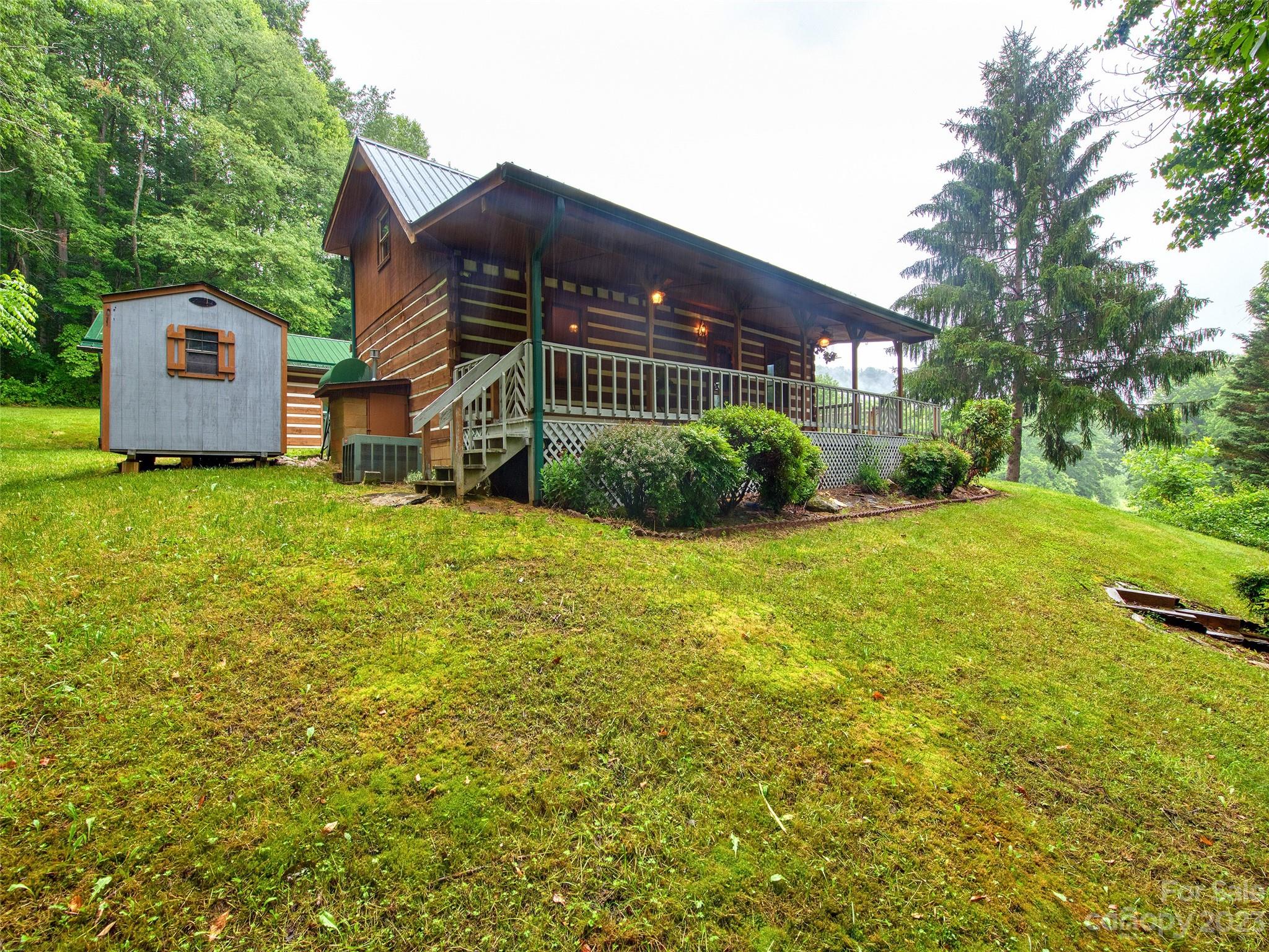 205 Columbus Cove Road Waynesville, NC 28785 - Photo 3 of 33 a view of a house with a big yard and large trees