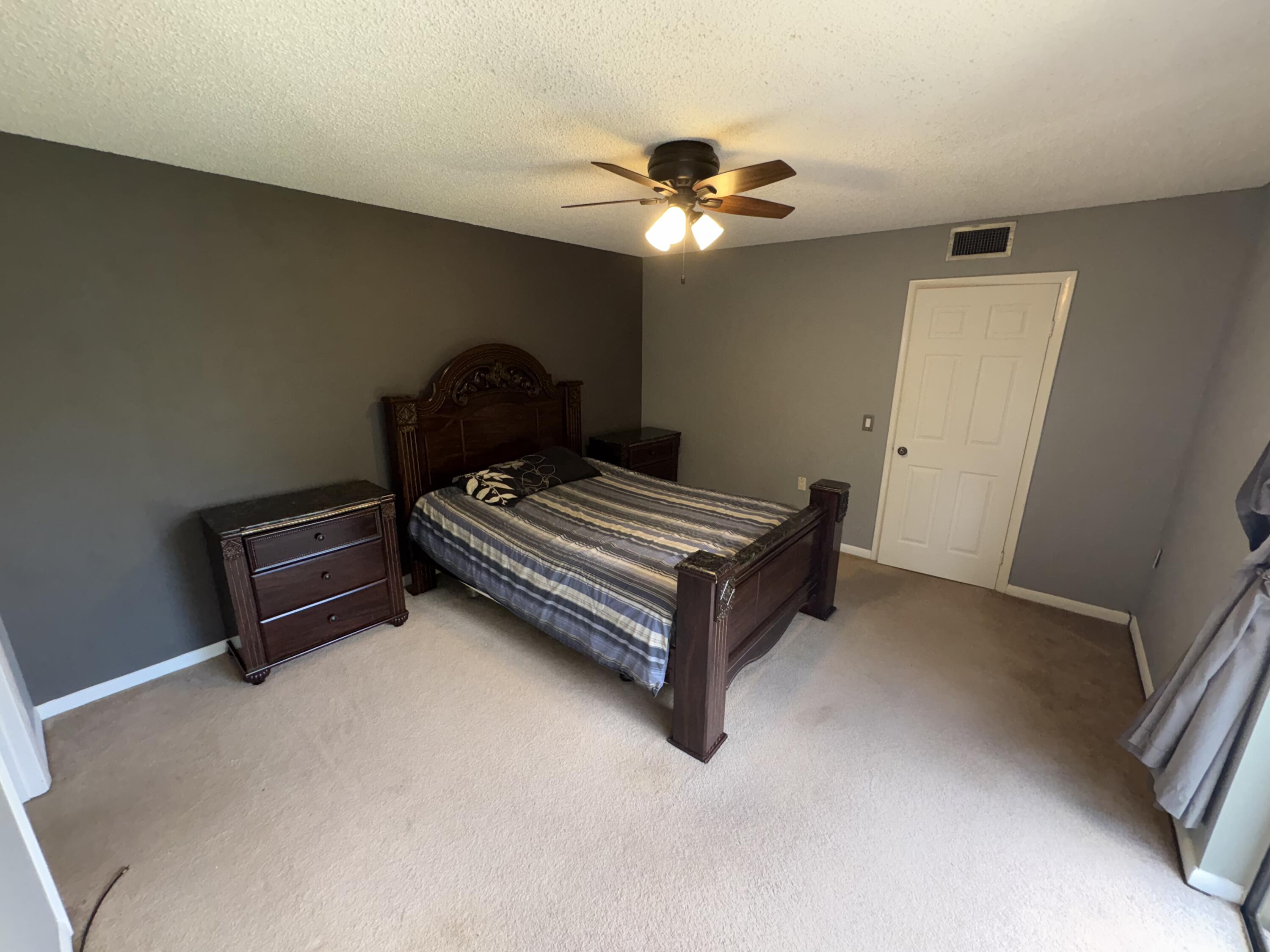 2950 Southwest 22nd Circle, Unit 4A Delray Beach, FL 33445 - Photo 19 of 42 a bedroom with a bed and a chandelier