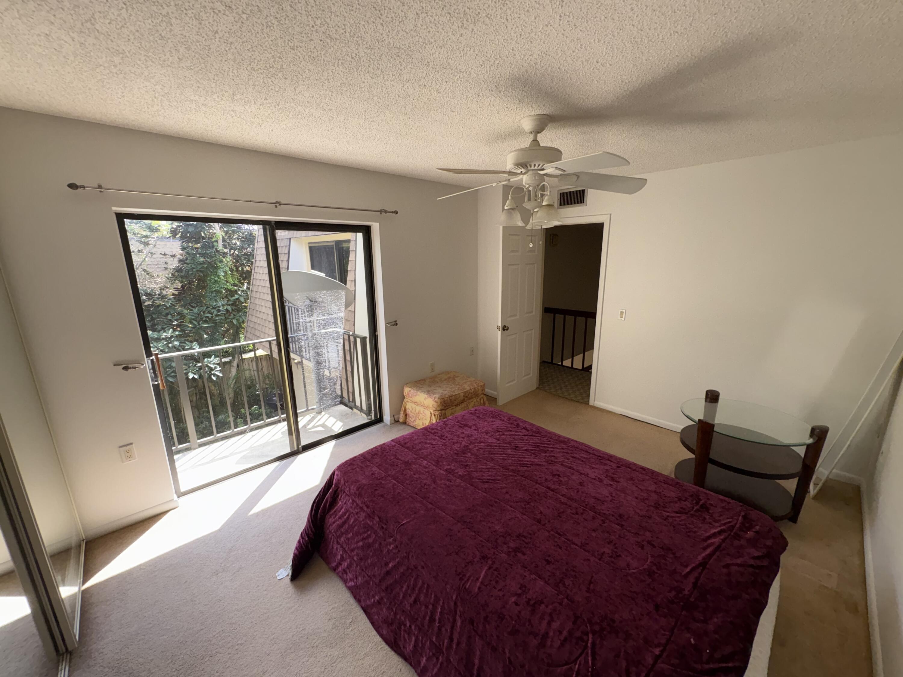 2950 Southwest 22nd Circle, Unit 4A Delray Beach, FL 33445 - Photo 23 of 42 a bedroom with a large bed and a chandelier