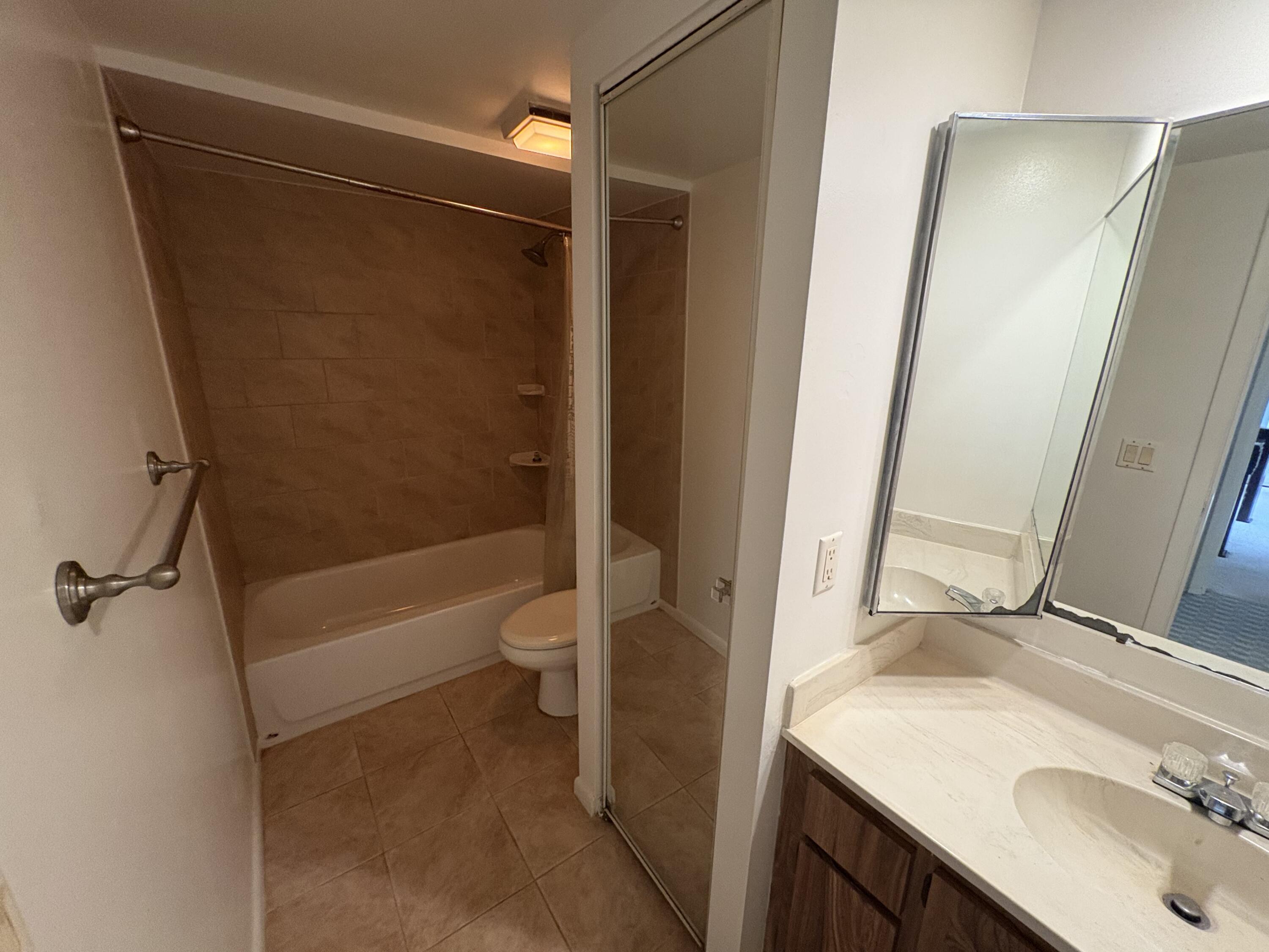 2950 Southwest 22nd Circle, Unit 4A Delray Beach, FL 33445 - Photo 25 of 42 a bathroom with a granite countertop sink toilet and shower