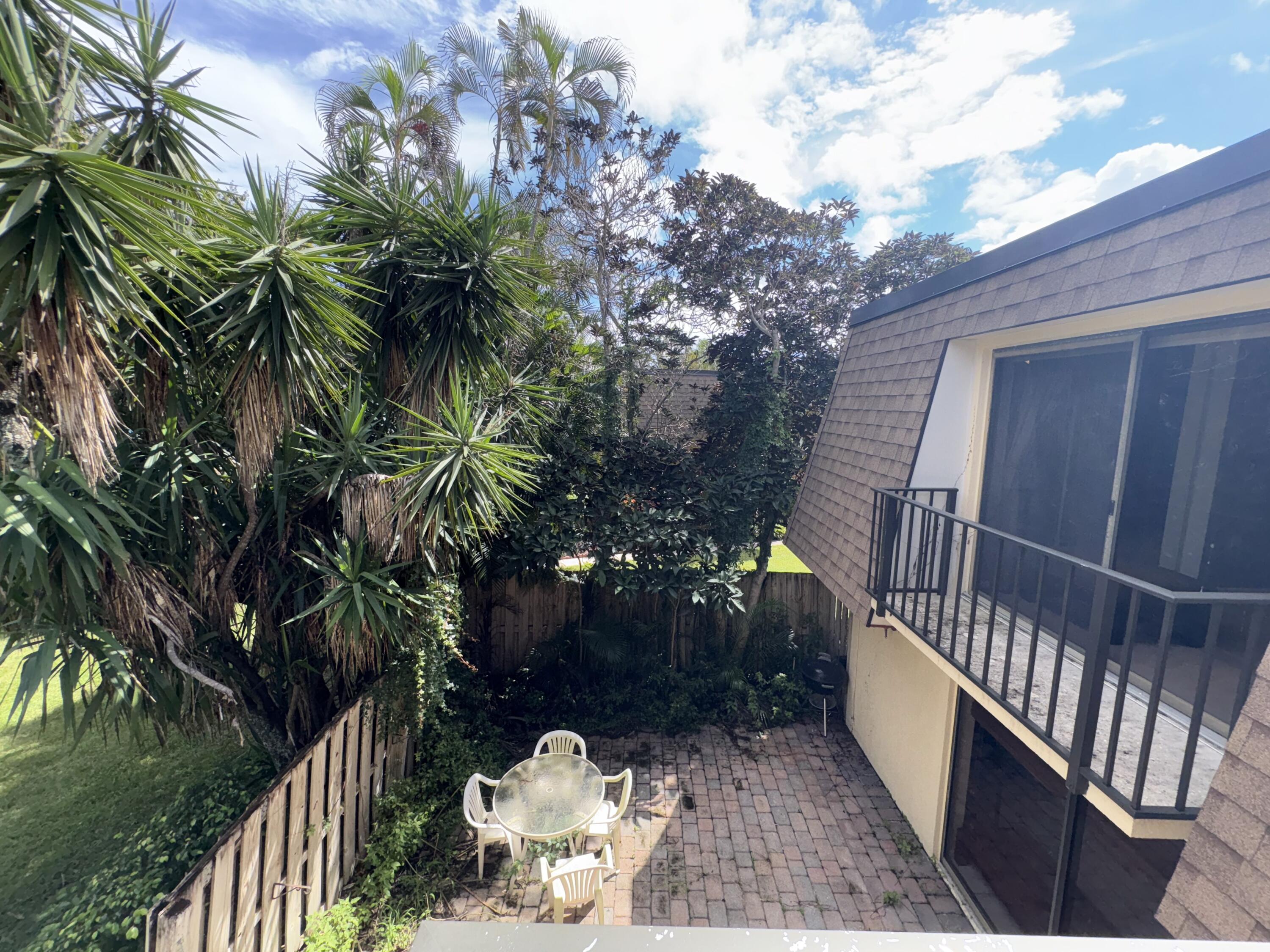 2950 Southwest 22nd Circle, Unit 4A Delray Beach, FL 33445 - Photo 27 of 42 a view of backyard with deck and outdoor seating