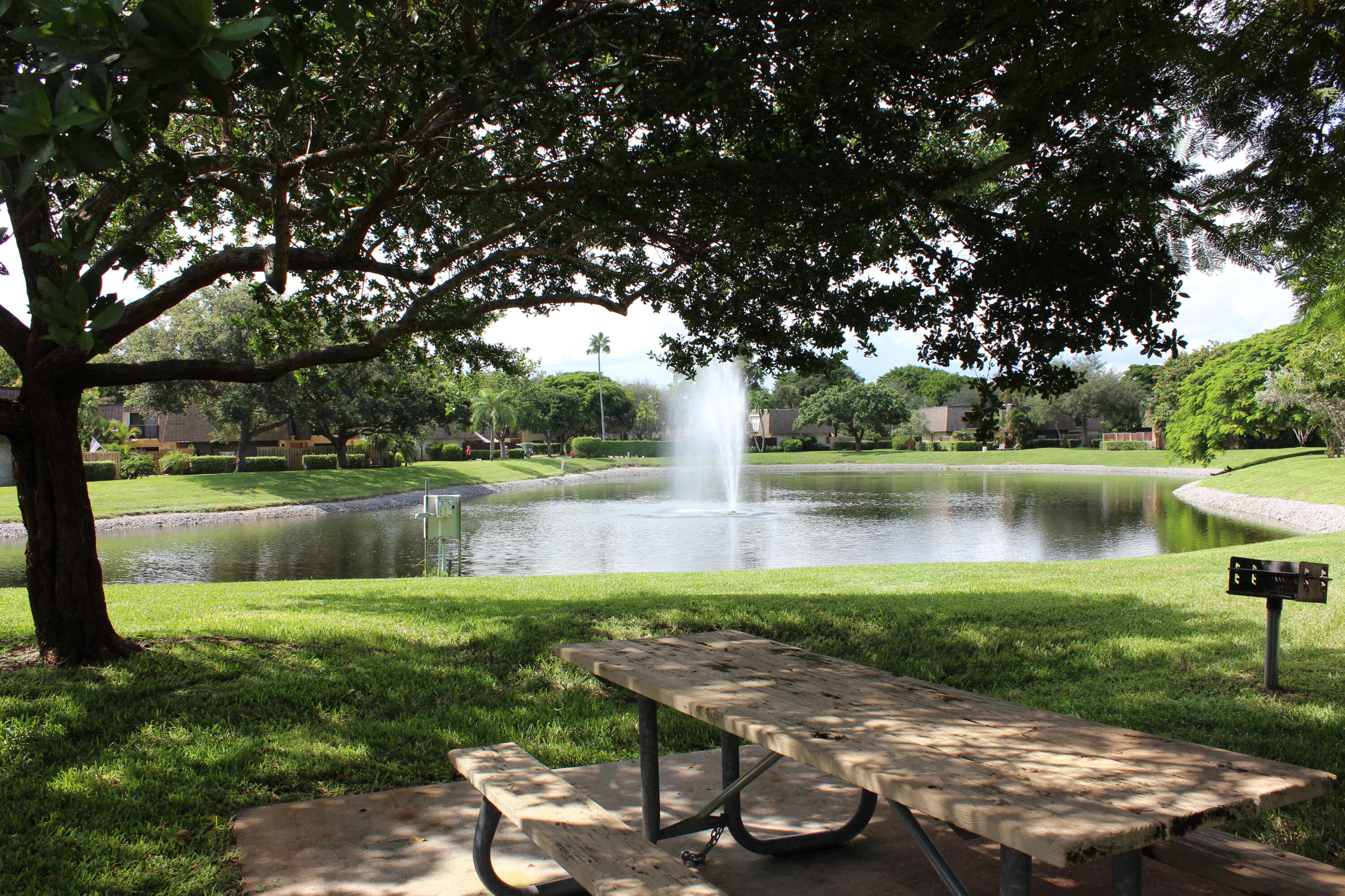 2950 Southwest 22nd Circle, Unit 4A Delray Beach, FL 33445 - Photo 33 of 42 a view of a lake with a yard and a large tree