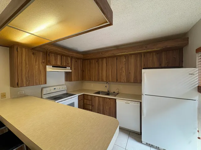 a kitchen with stainless steel appliances a refrigerator sink and white cabinets