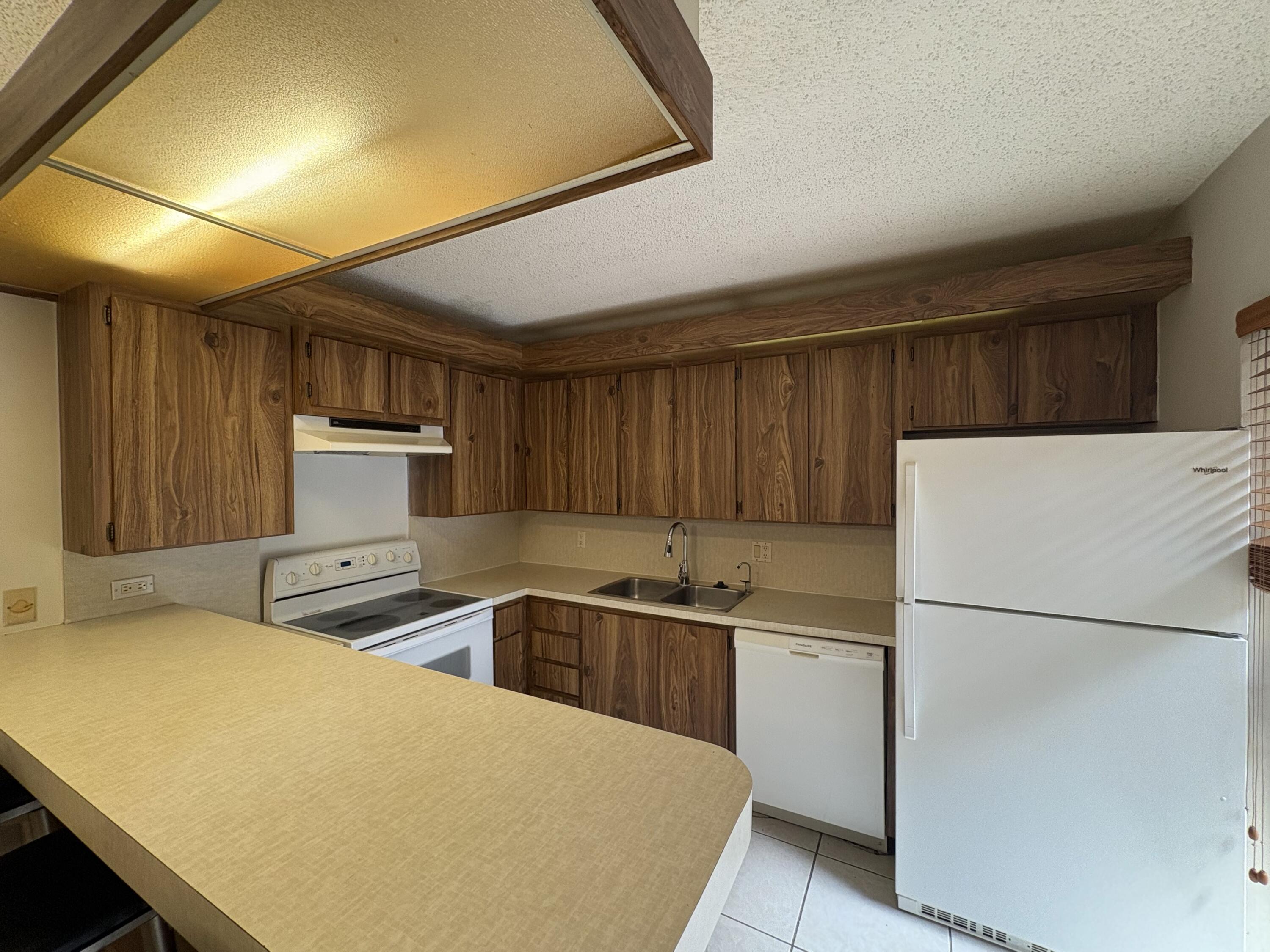 2950 Southwest 22nd Circle, Unit 4A Delray Beach, FL 33445 - Photo 7 of 42 a kitchen with stainless steel appliances a refrigerator sink and white cabinets
