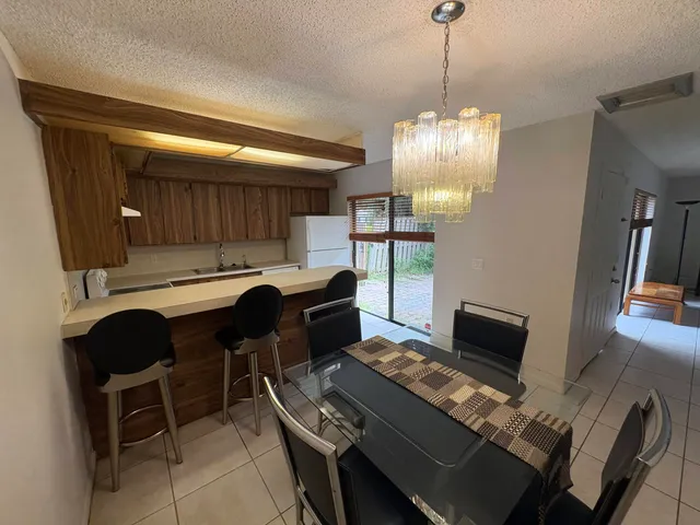 a workspace with furniture a chandelier and wooden floor