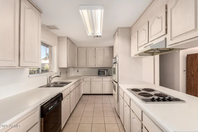 a kitchen with a stove sink and cabinets