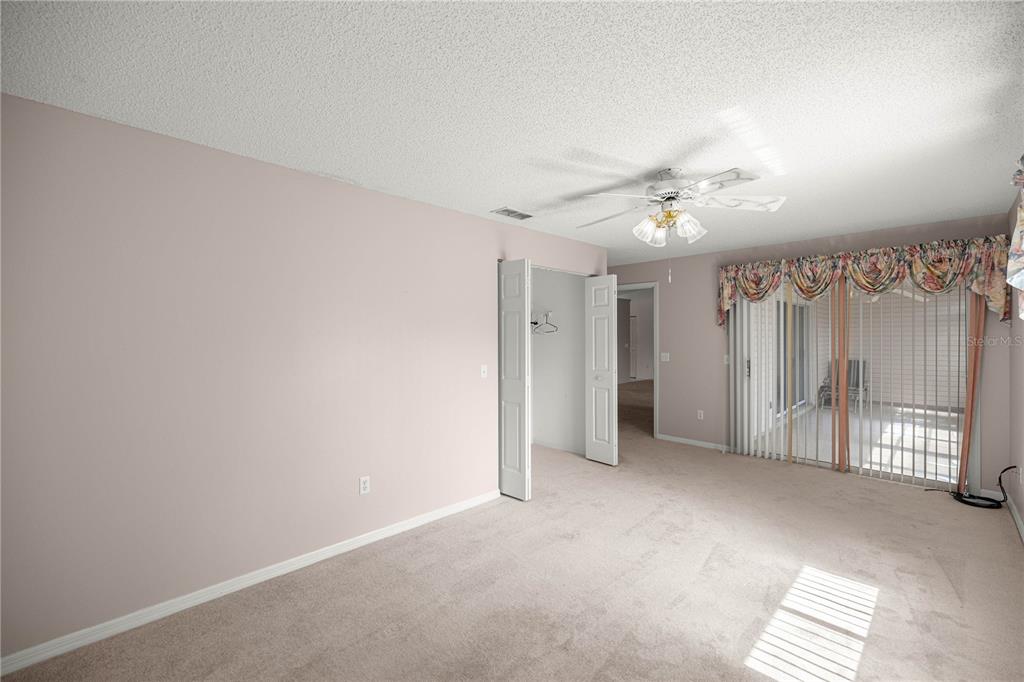 8485 Southwest 60th Circle Ocala, FL 34476 - Photo 12 of 22 an empty room with windows and fan