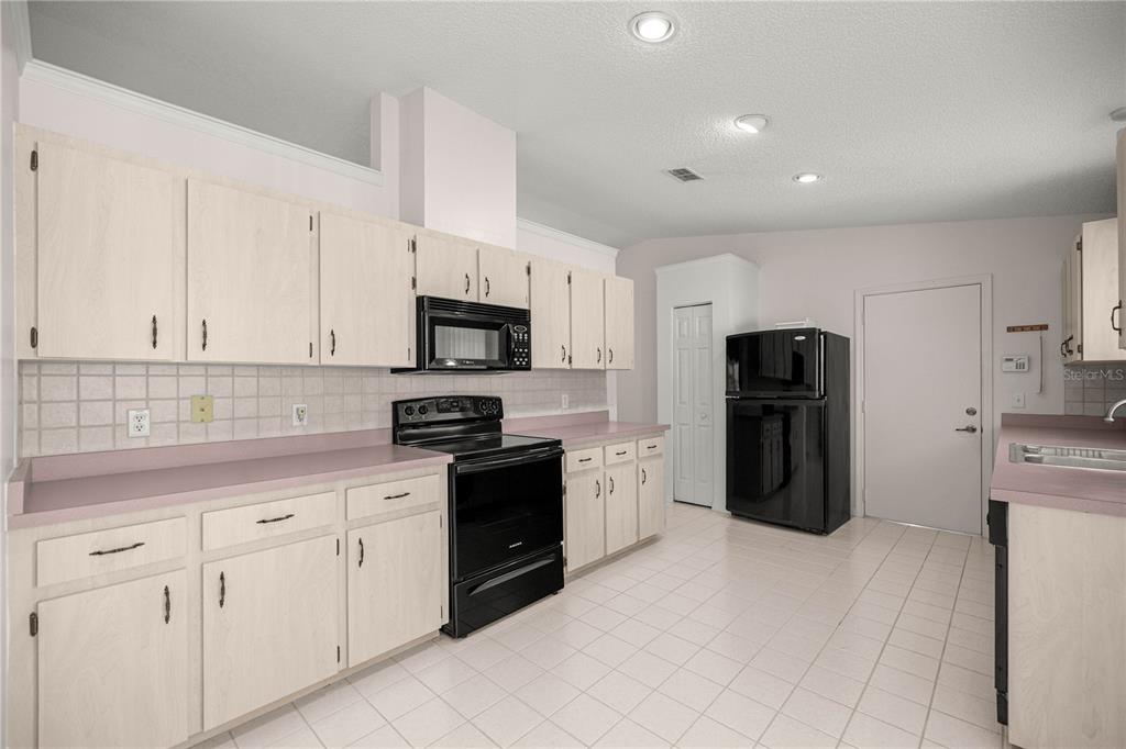 8485 Southwest 60th Circle Ocala, FL 34476 - Photo 7 of 22 a kitchen with white cabinets and stainless steel appliances