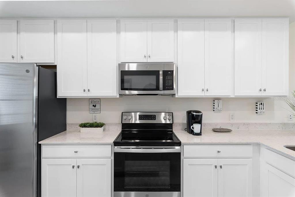 17724 Gawthrop Drive, Unit 204 Bradenton, FL 34211 - Photo 15 of 55 a kitchen with stainless steel appliances granite countertop white cabinets and a stove a oven with white countertops