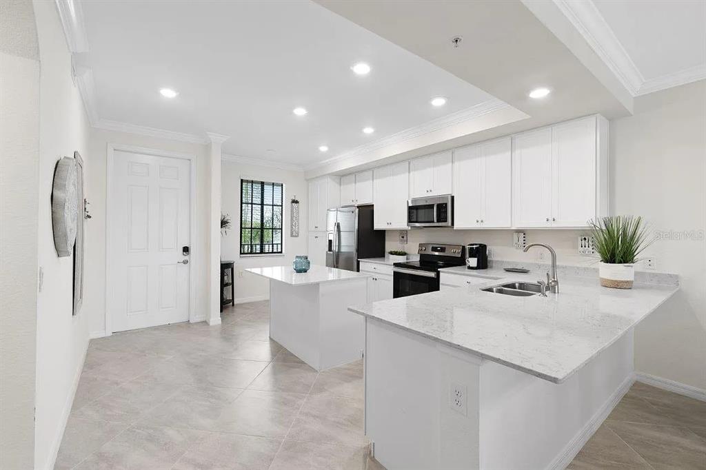 17724 Gawthrop Drive, Unit 204 Bradenton, FL 34211 - Photo 16 of 55 a kitchen with stainless steel appliances a refrigerator sink and white cabinets