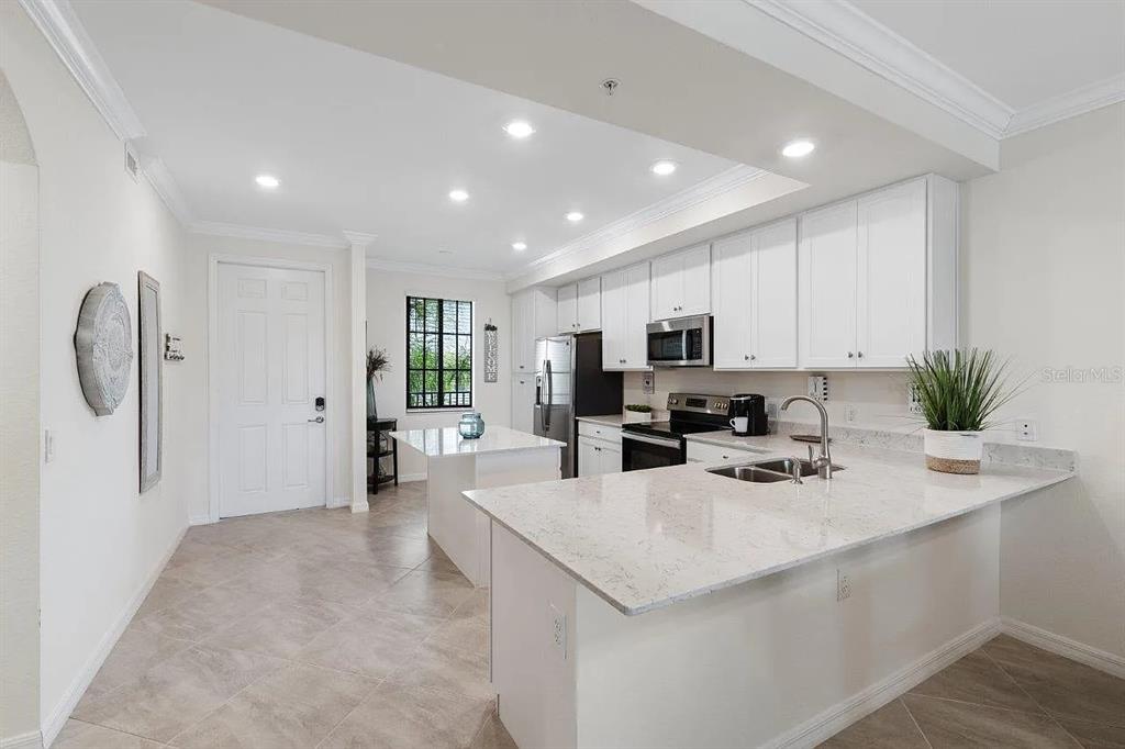 17724 Gawthrop Drive, Unit 204 Bradenton, FL 34211 - Photo 17 of 55 a kitchen with stainless steel appliances kitchen island granite countertop a refrigerator and a sink