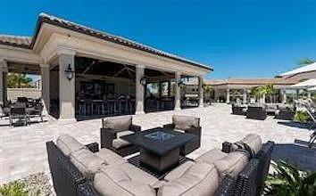 17724 Gawthrop Drive, Unit 204 Bradenton, FL 34211 - Photo 40 of 55 a view of a patio with dining table and chairs with wooden floor and fence
