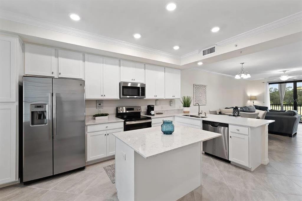 17724 Gawthrop Drive, Unit 204 Bradenton, FL 34211 - Photo 7 of 55 a kitchen with white cabinets and stainless steel appliances