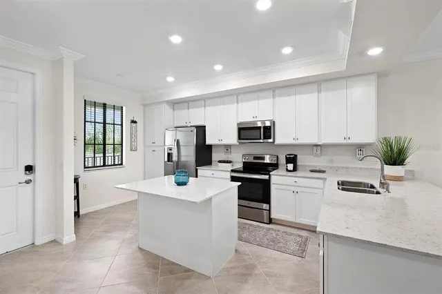 a kitchen with white cabinets stainless steel appliances and sink