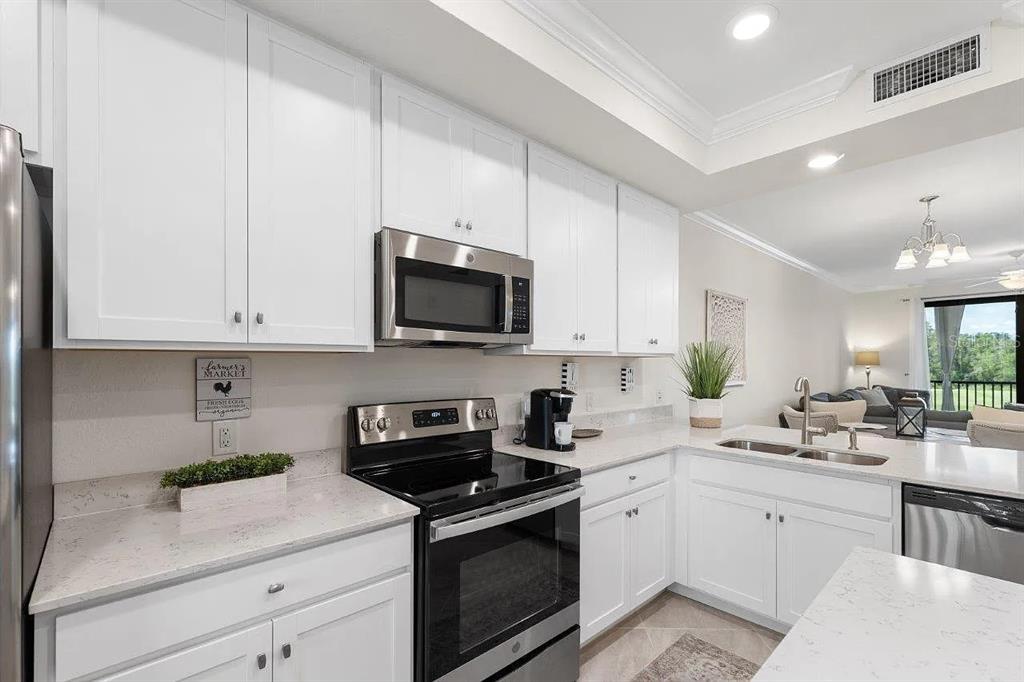 17724 Gawthrop Drive, Unit 204 Bradenton, FL 34211 - Photo 9 of 55 a kitchen with white cabinets stainless steel appliances and sink