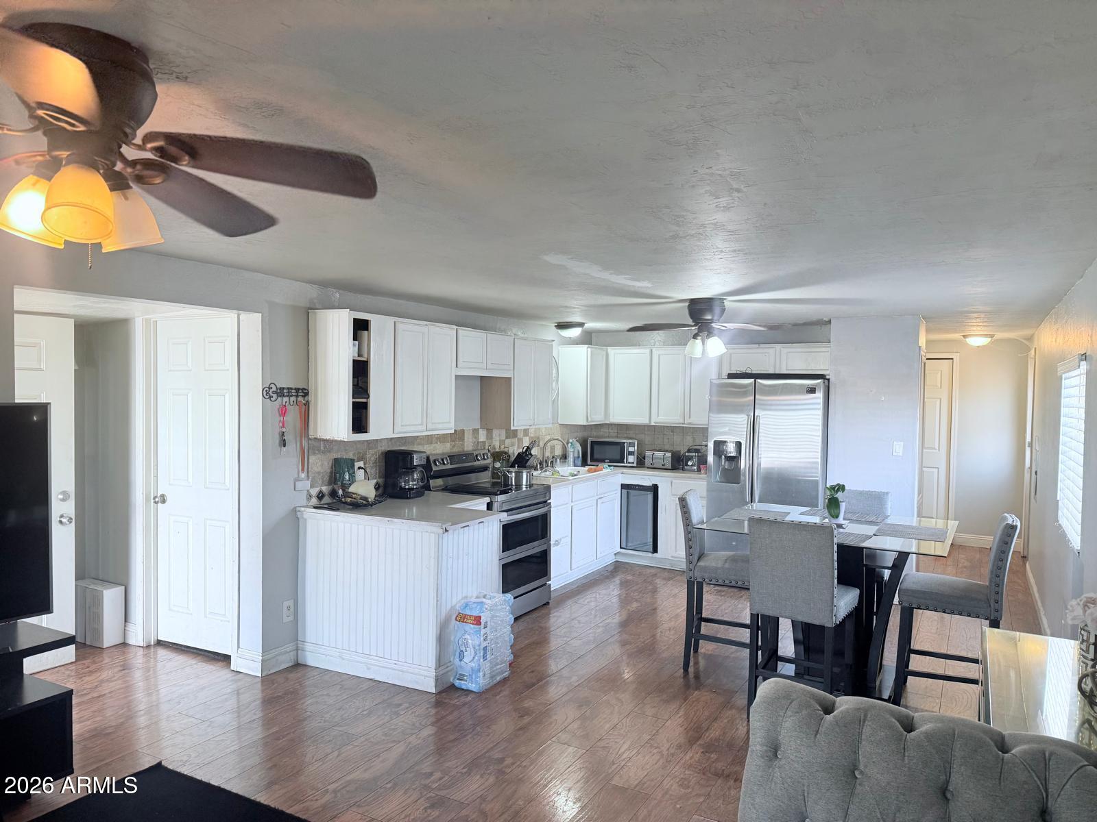130 East McKellips Road, Unit 47 Mesa, AZ 85201 - Photo 2 of 6 a kitchen with a dining table chairs and refrigerator