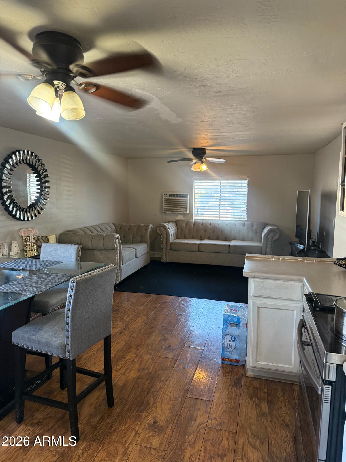 130 East McKellips Road, Unit 47 Mesa, AZ 85201 - Photo 4 of 6 a living room with a couch and a dining table with wooden floor