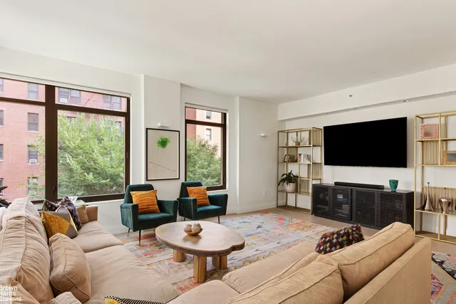 a living room with furniture a flat screen tv and a large window