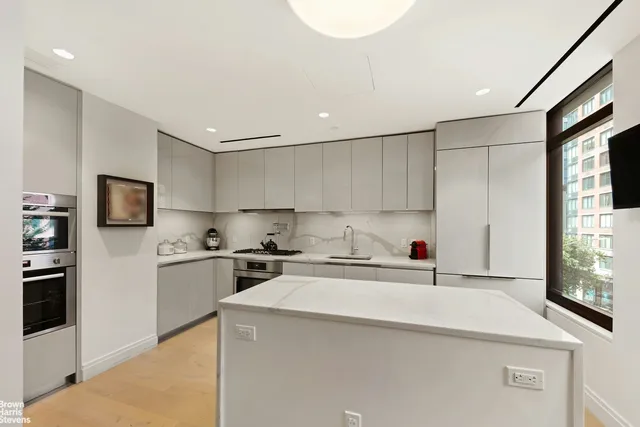 a kitchen with stainless steel appliances a sink stove top oven and white cabinets