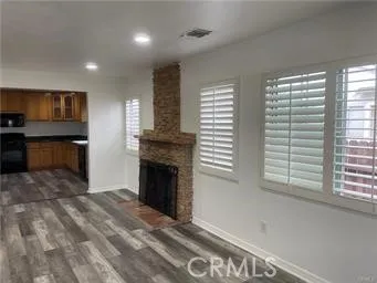 a view of empty room with a fireplace and windows