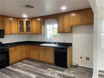 a kitchen with stainless steel appliances granite countertop wooden cabinets a stove top oven a sink and dishwasher