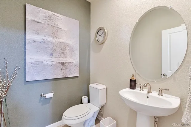a bathroom with a sink mirror and toilet