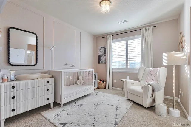 a spacious bedroom with furniture and mirror