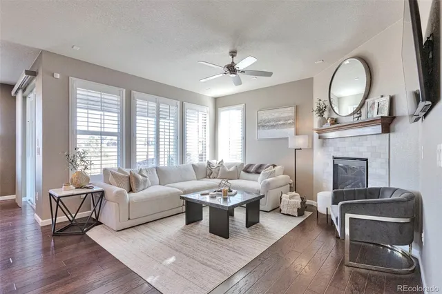 a living room with fireplace furniture and a large window