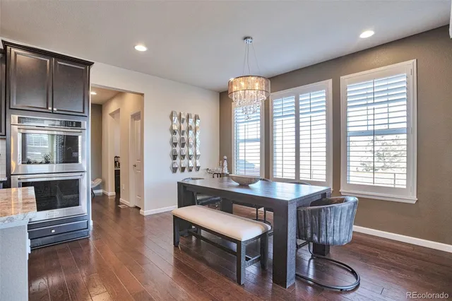 a kitchen with stainless steel appliances granite countertop a stove a refrigerator and wooden floor