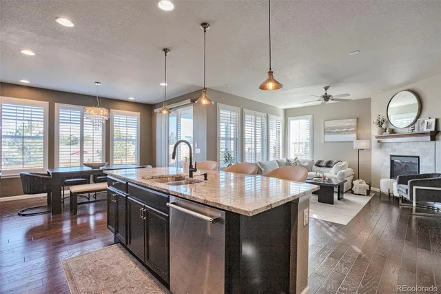 a large kitchen with stainless steel appliances granite countertop a stove a sink a oven a dining table and chairs with wooden floor