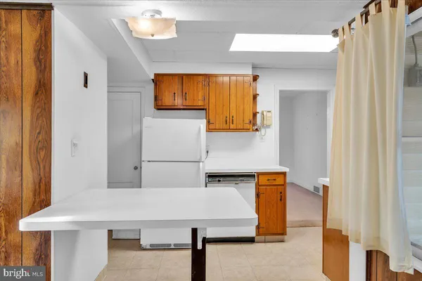 a kitchen with stainless steel appliances a stove a sink and a refrigerator with wooden cabinets