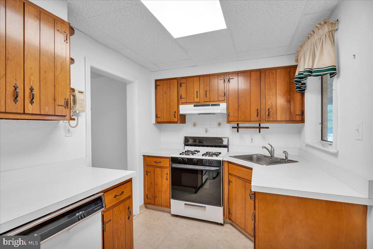 263 Hopkins Road Haddonfield, NJ 08033 - Photo 16 of 38 a kitchen with stainless steel appliances a stove a sink and a refrigerator with wooden cabinets