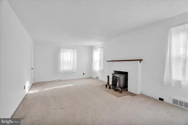 an empty room with fireplace and windows