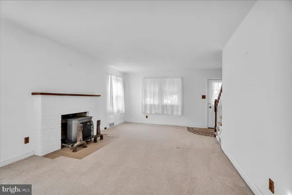 an empty room with fireplace and windows