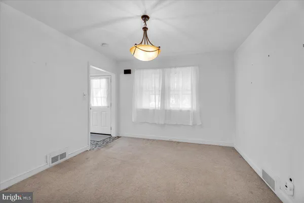 an empty room with windows and chandelier fan