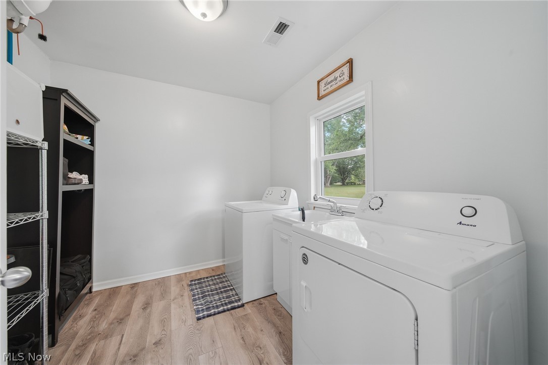 3471 State Rte 5 Newton Falls, OH 44444 - Photo 10 of 31 Laundry area featuring wood-finish flooring, white walls, and a window with exterior views