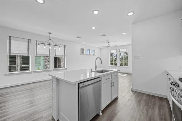 a kitchen with sink stove and wooden floor