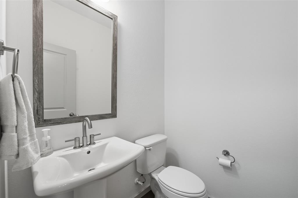 228 Spring Hill Road Flower Mound, TX 75028 - Photo 14 of 31 a bathroom with a sink mirror and toilet